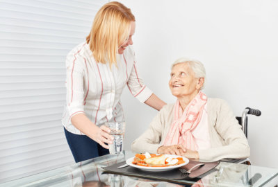 caregiver serving her patient her meal