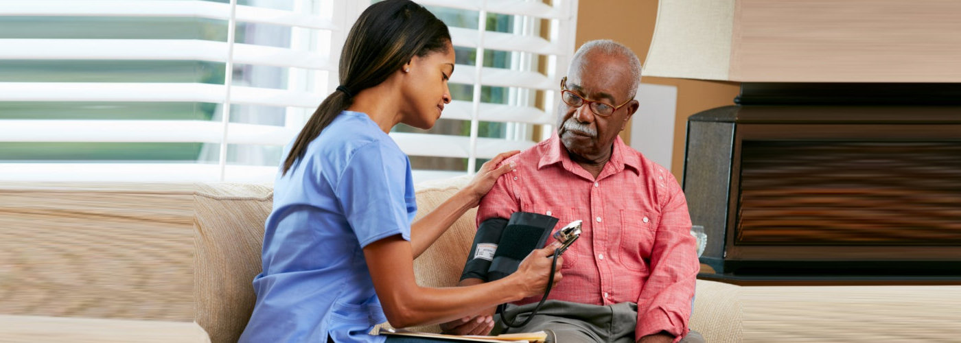 caregiver checking her patient blood pressure